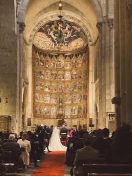 Beautiful bridal couple during a wedding ceremony in a historic church with stunning architecture.