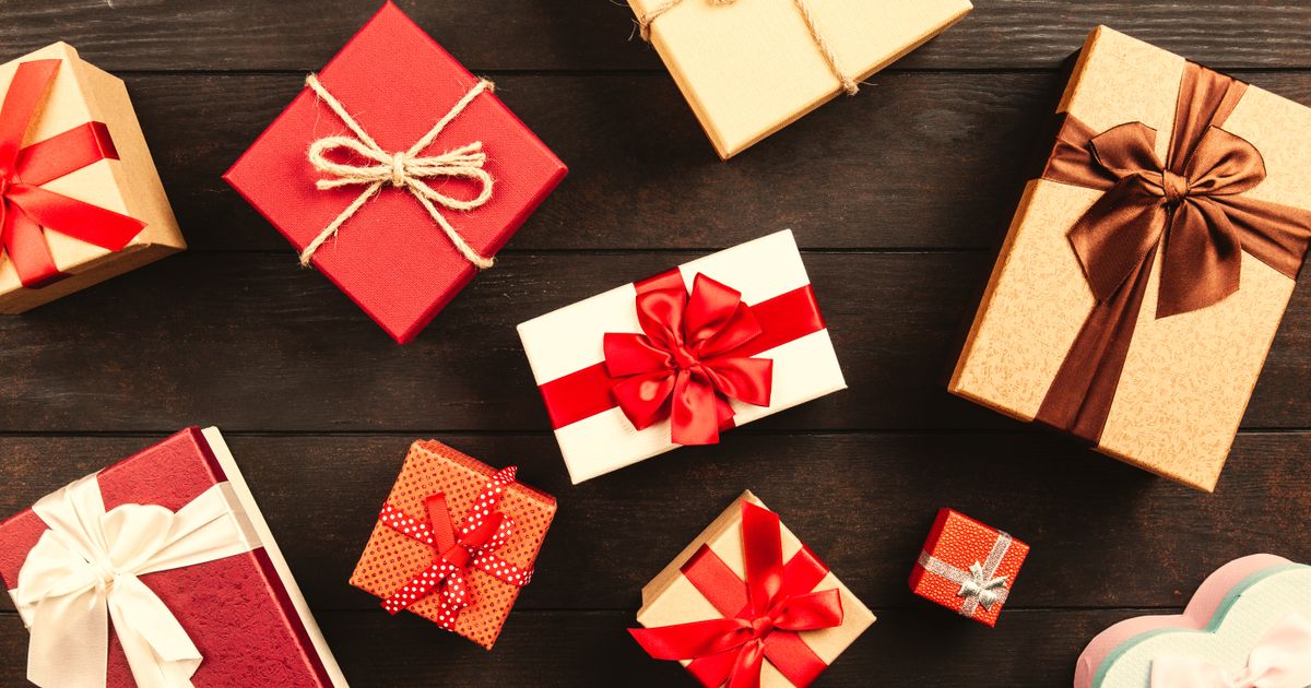 Beautifully wrapped gift boxes with gold ribbons arranged on a table