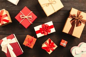 Wrapped gift boxes on a dark wood table — photo by George Dolgikh on Pexels