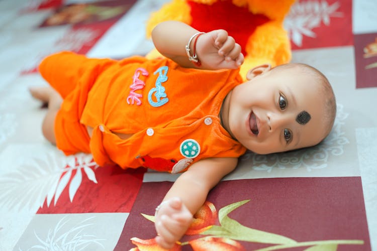 Smiling Baby Lying On The Floor