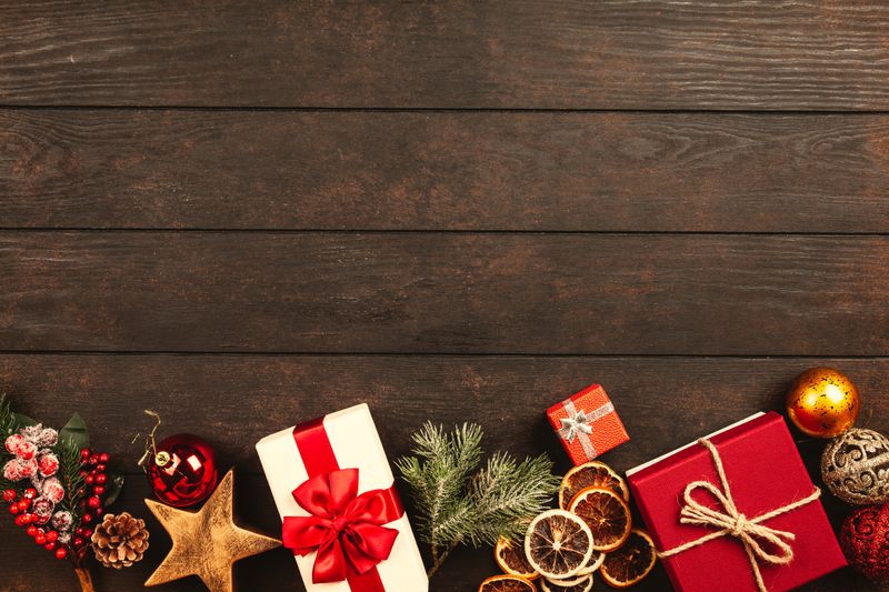 Christmas gifts and festive decorations on a dark wood surface
