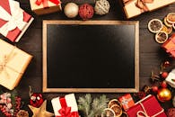 黑板自上而下的视图，周围环绕着圣诞礼物和装饰品，并留有文字空间