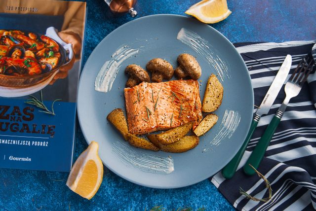 Delicious salmon fillet served with potatoes and mushrooms on a stylish blue plate.