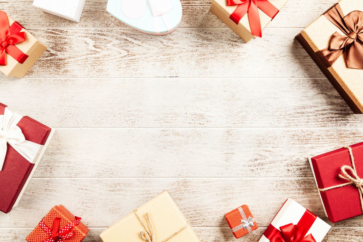 Top-down view of colorful wrapped gift boxes with ribbons arranged on a rustic wooden table