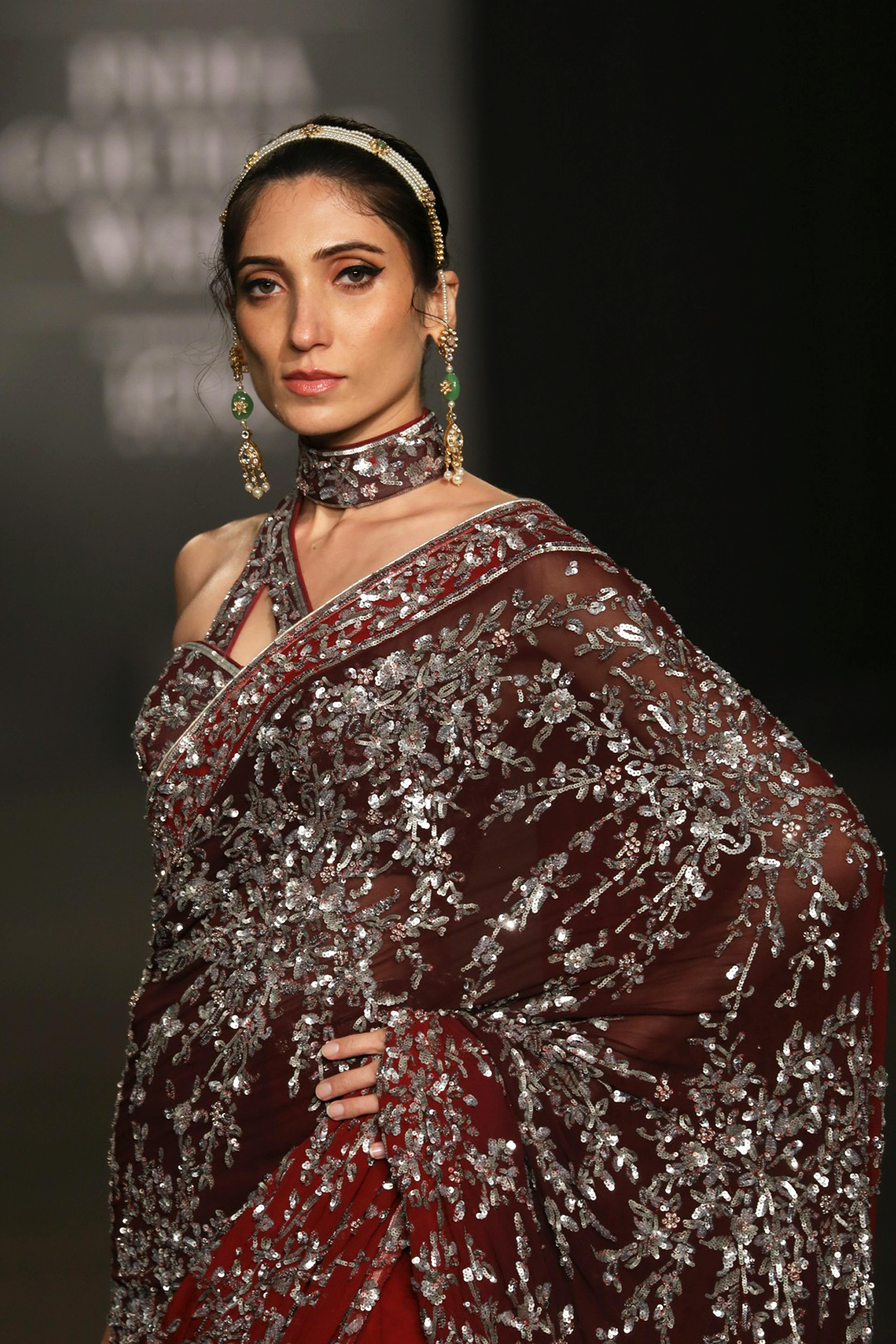 model in red sari with silver sequin floral patterns