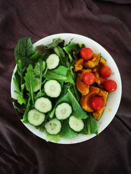 Vibrant salad bowl with fresh cucumbers, tomatoes, and leafy greens showcasing a healthy lifestyle.