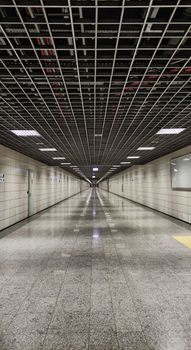 A symmetrical underground corridor with grid ceiling and lights in Istanbul. — photo by Sıla