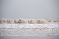 Captivating image of powerful waves crashing at the shoreline under cloudy skies.