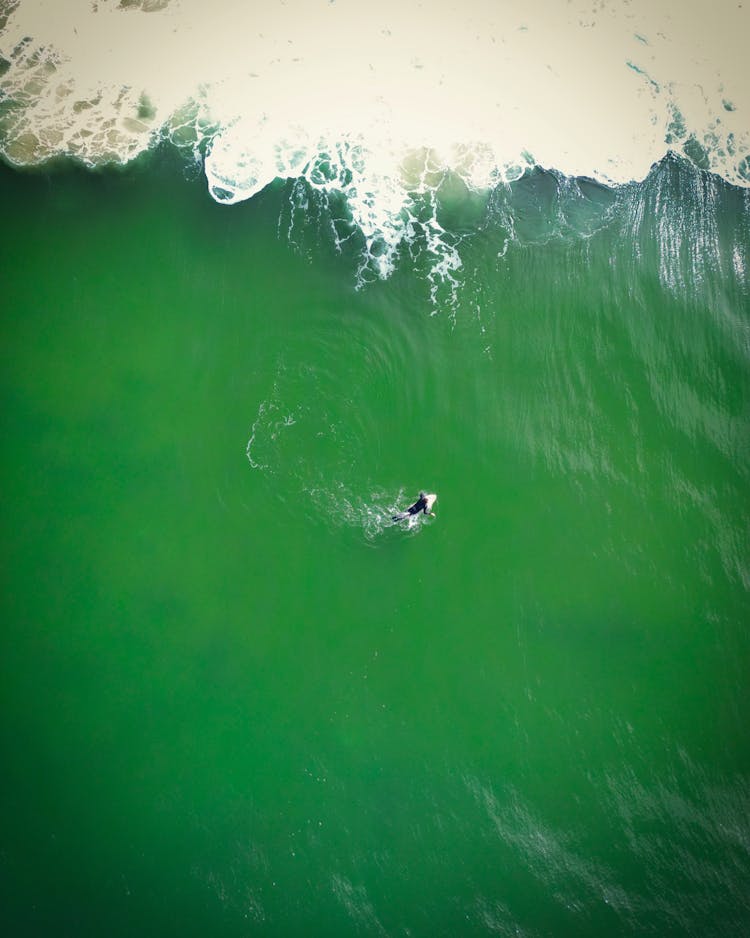 An Aerial Photography Of A Person Surfing On The Sea