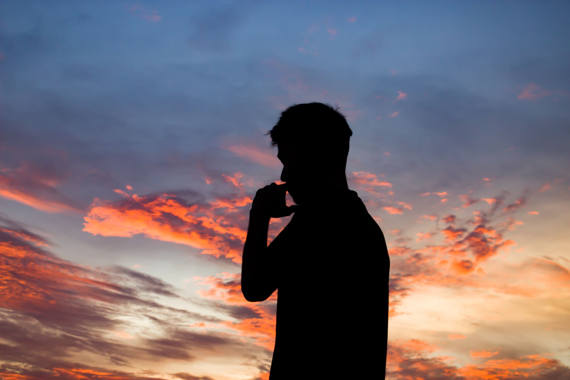 A striking silhouette of a man contemplating under a colorful sunset sky, evoking a sense of tranquility.. pexels, striking,