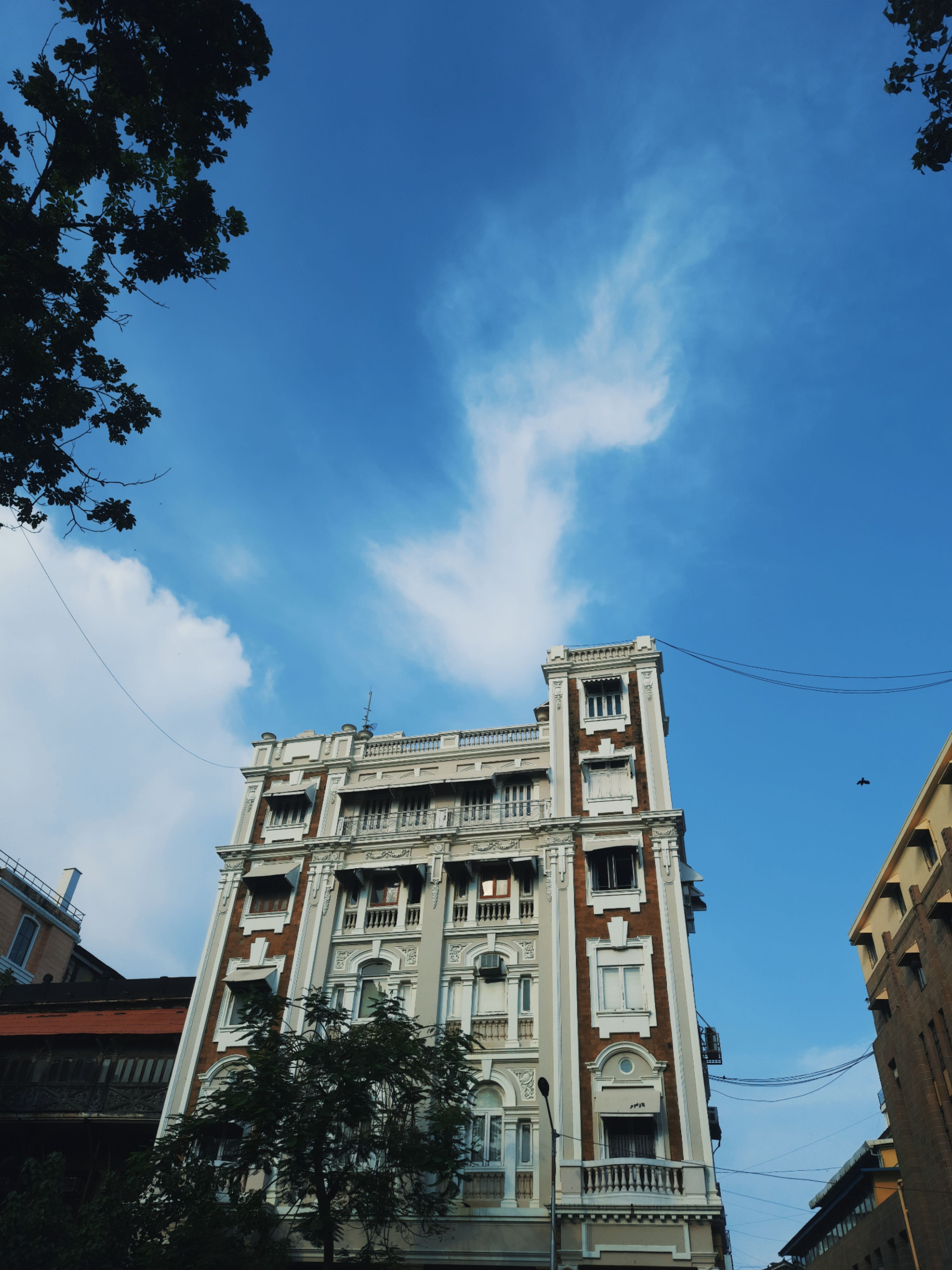 A Low Angle Shot of a Building Under the Blue Sky and White Clouds ...