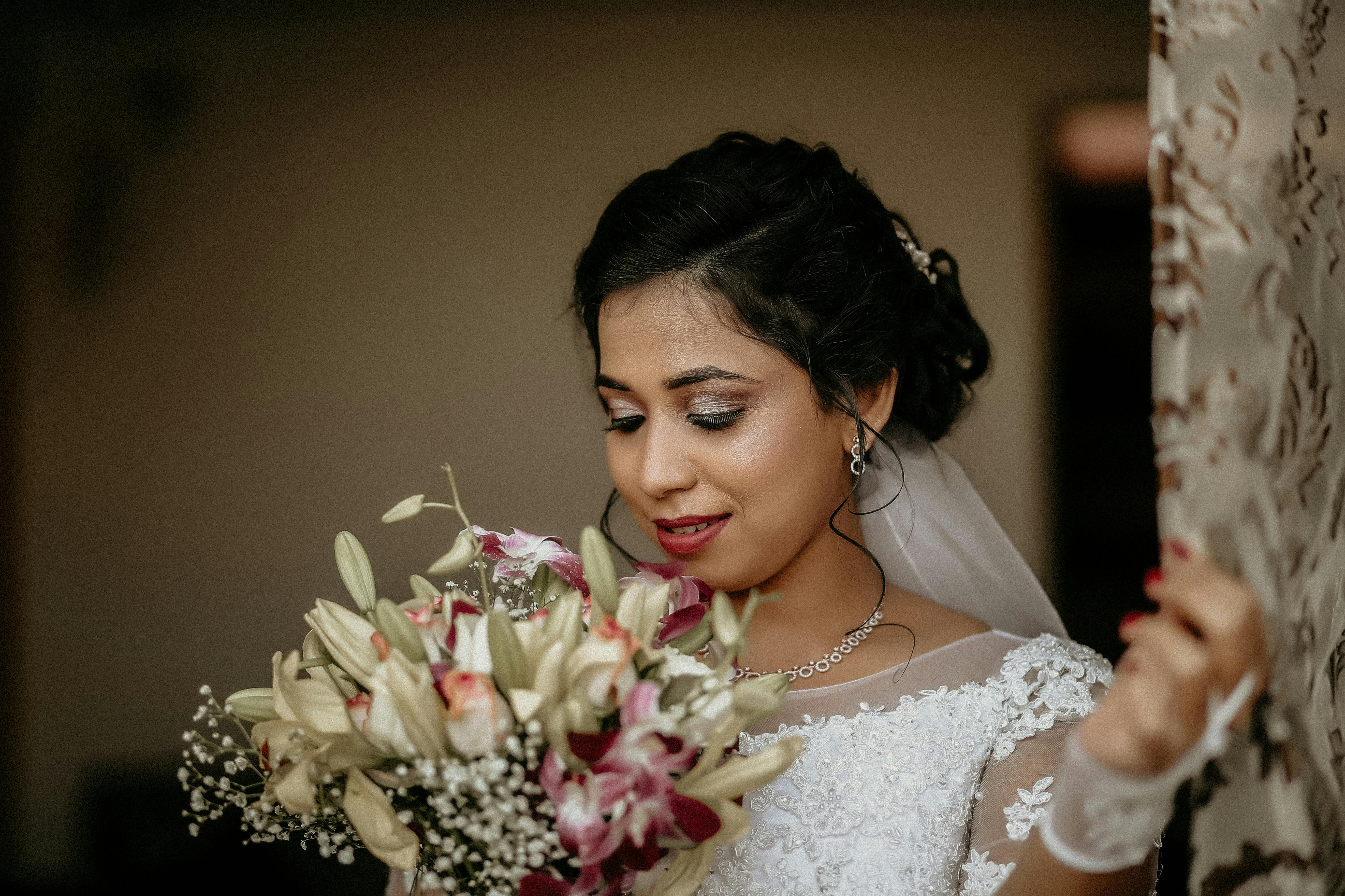 Close Up Photo of Bride Looking at Bouquet of Flowers · Free Stock Photo