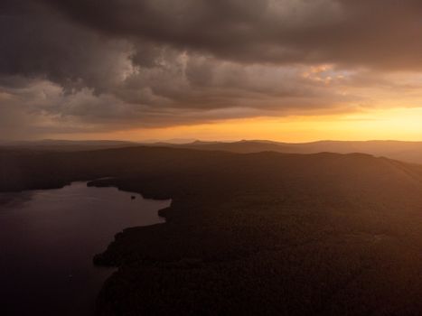 A breathtaking aerial view of a mountain landscape at sunset with dramatic clouds.