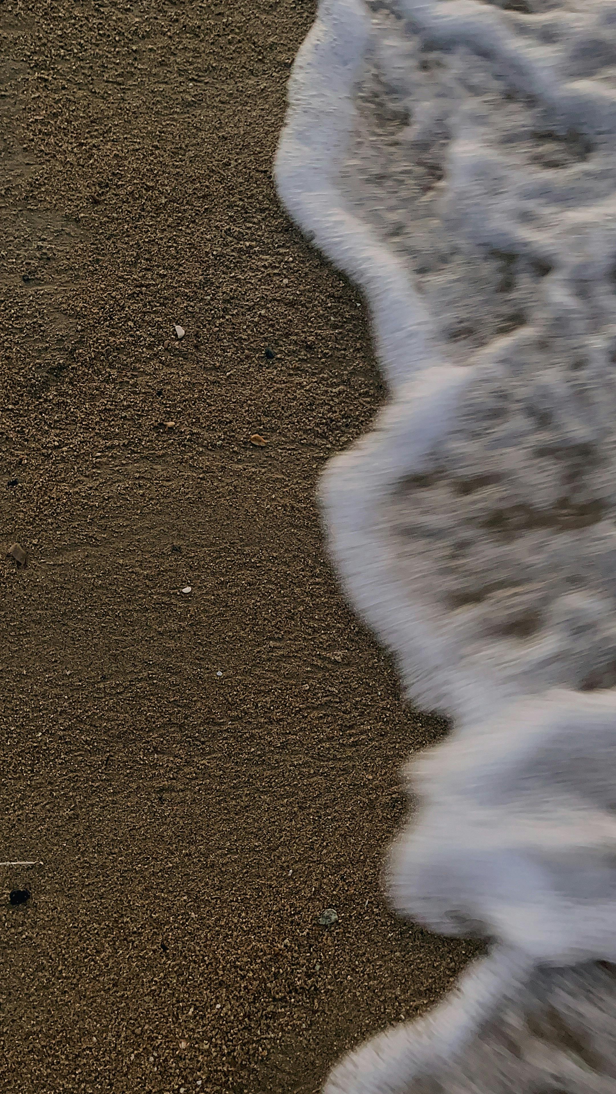 Close-Up Shot of Crashing Sea Waves on Beach Sand · Free Stock Photo