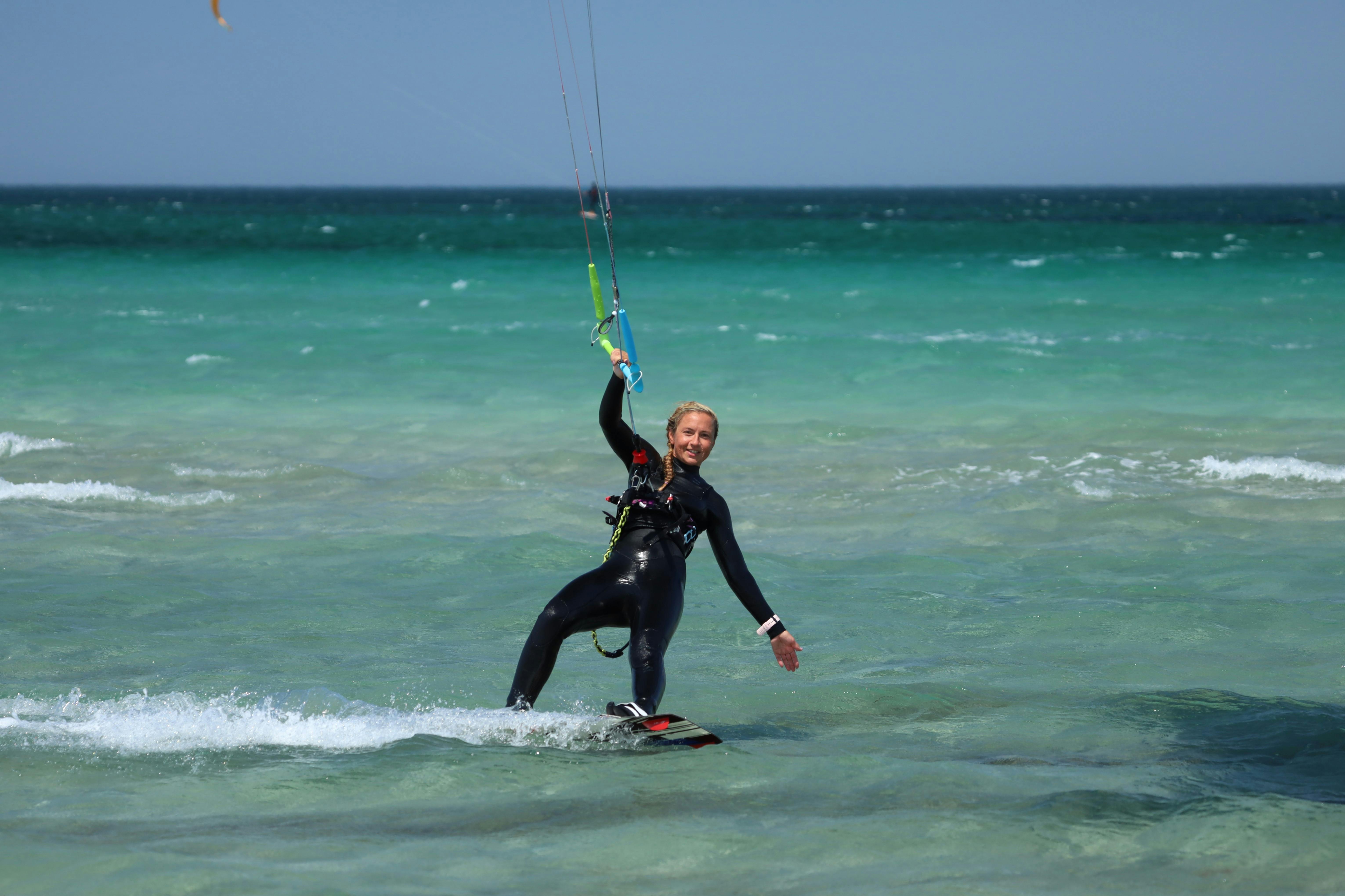 A Woman in Black Wetsuit Kiteboarding on Sea · Free Stock Photo