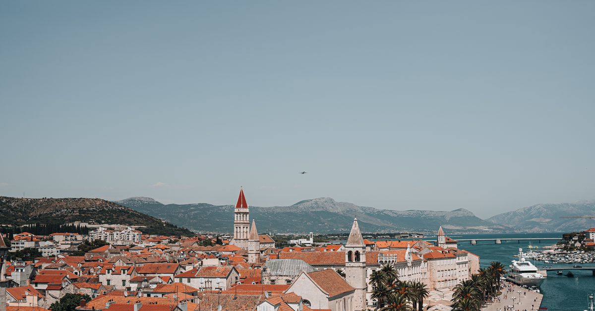 Aerial view of Trogir, Croatia showcasing red rooftops, coastline, and historic architecture.