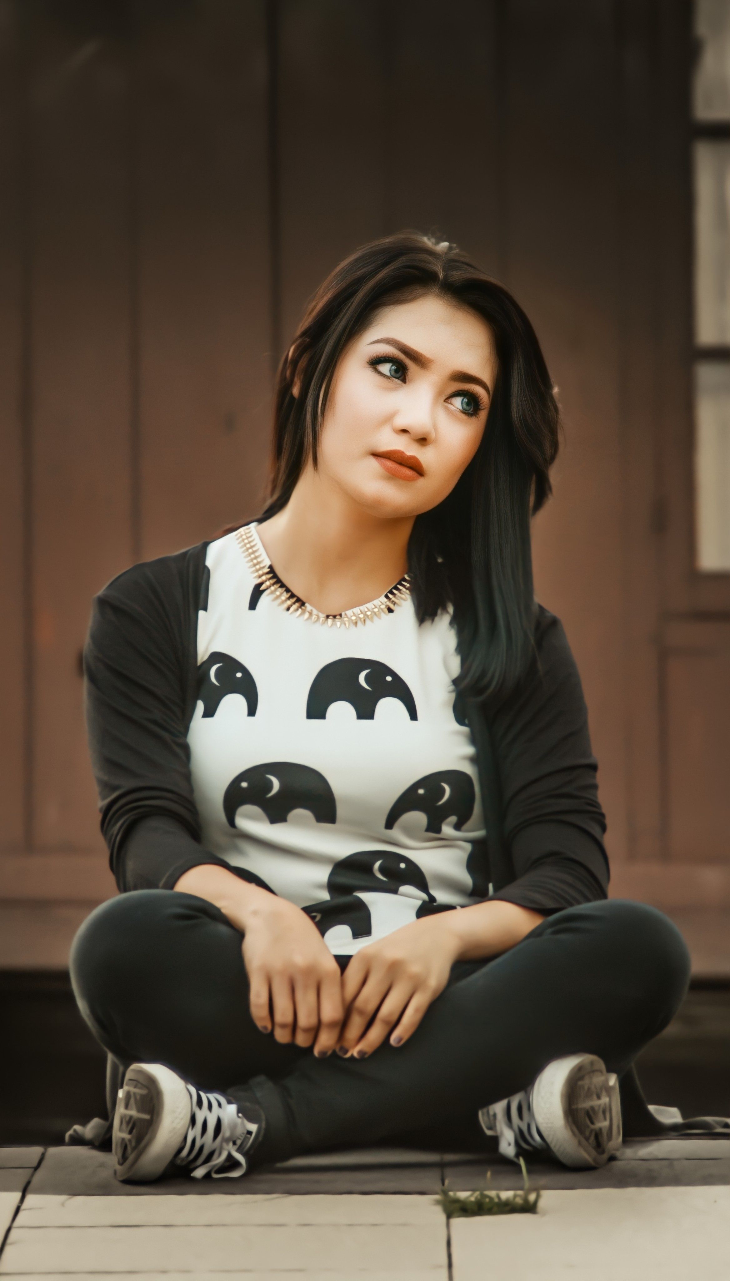 Young Asian woman sitting outdoors in a casual black and white outfit, Makassar