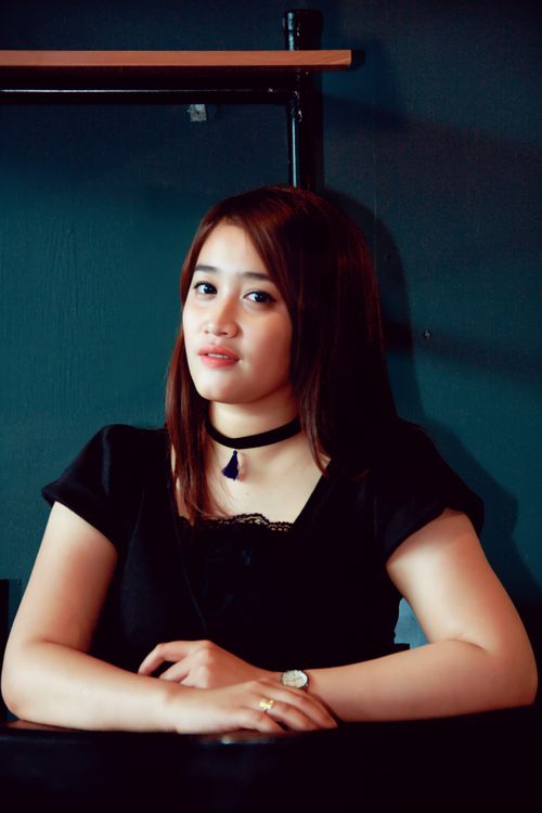 Free Elegant portrait of a young Asian woman wearing a black shirt and choker indoors. Stock Photo
