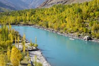 雄伟的山谷中，风景如画的河流呈现出充满活力的秋色