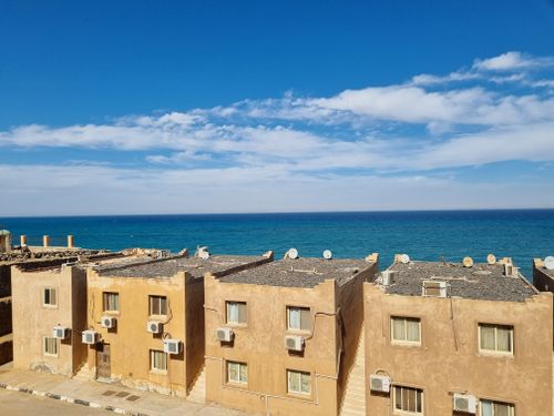 Free Aerial view of seaside town with rustic buildings and clear blue ocean. Stock Photo