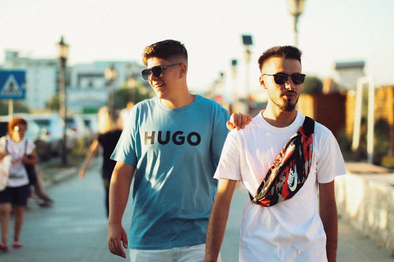 Deux jeunes hommes marchant ensemble lors d'un coucher de soleil à Năvodari, Roumanie