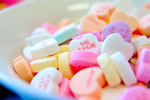 A close-up of colorful heart-shaped candies with romantic messages, ideal for Valentine's Day.