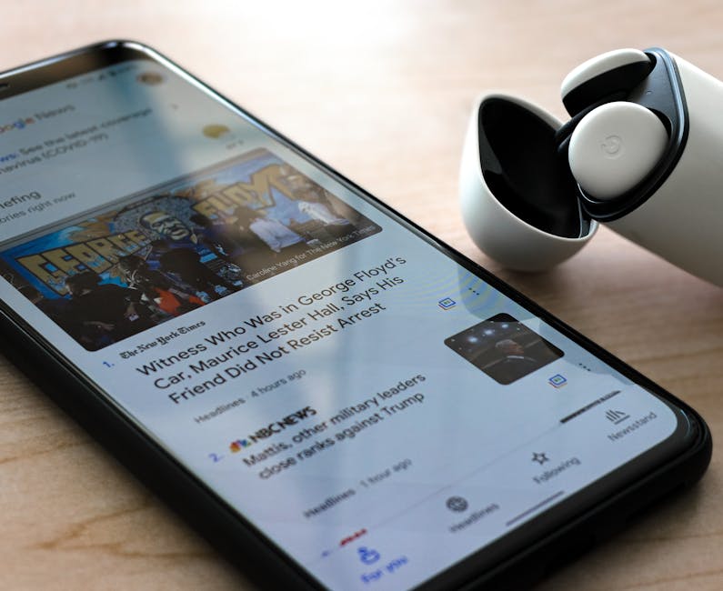 Kuinka päivitys tehdään - automaattinen vai manuaalinen Kuinka päivitys tehdään - automaattinen vai manuaalinen - Close-up of a smartphone displaying news with wireless earphones on