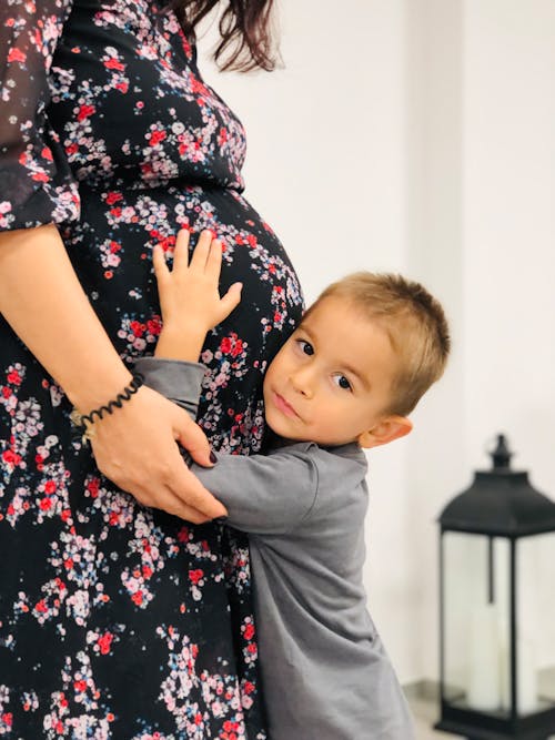 Boy Hugging a Pregnant Woman