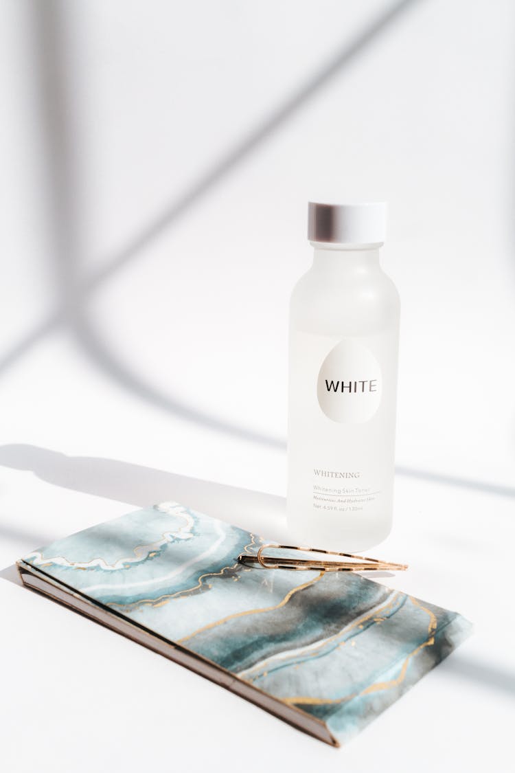 Water Bottle And A Notebook With A Marble Pattern Cover 