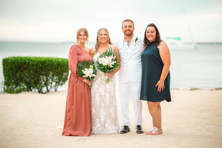 Wedding Photography Of Four People Standing On The Beach