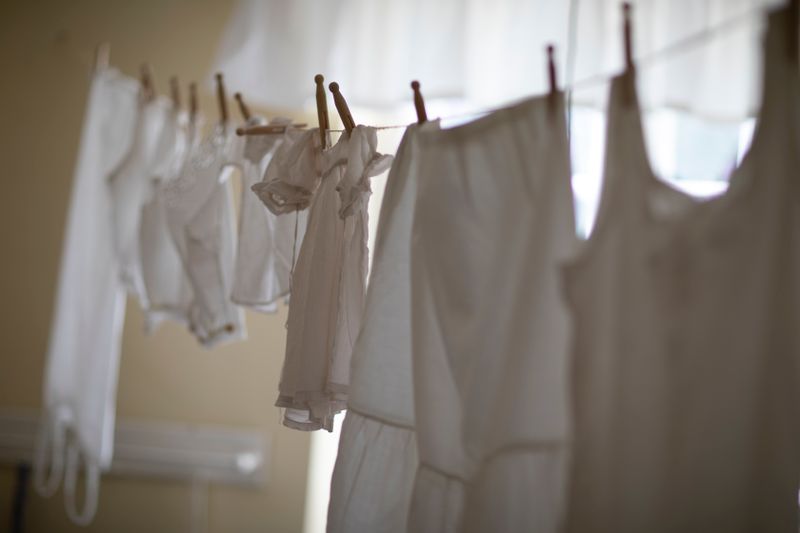 Freshly washed laundry hanging to dry on an indoor line in a single well-lit room