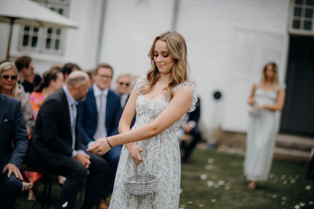 Convidada de casamento em vestido floral em ambiente ao ar livre, look de casamento de dia