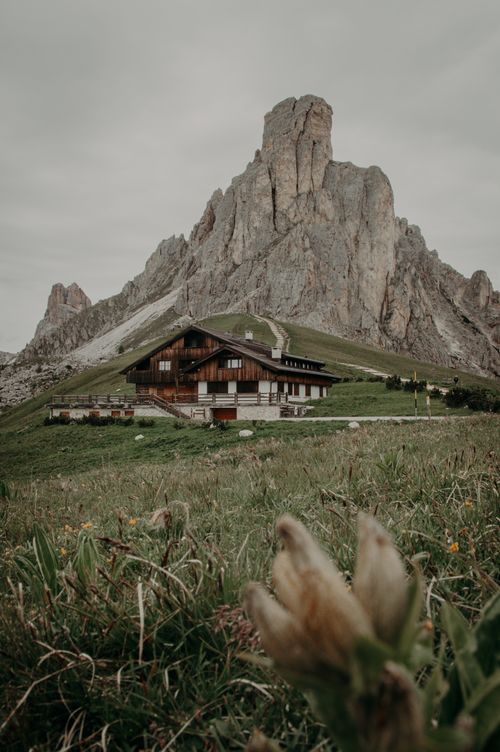 Free Rustic wooden chalet nestled in the majestic Dolomites mountains during a cloudy day. Stock Photo
