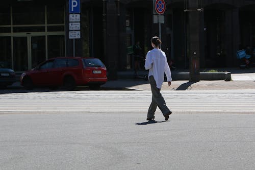 A Woman in White Long Sleeves Walking on the Street