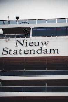 Detailed view of the Nieuw Statendam cruise ship exterior showcasing its name and structure.