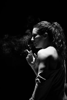 Artistic black and white photo of a woman smoking, capturing smoke trails.