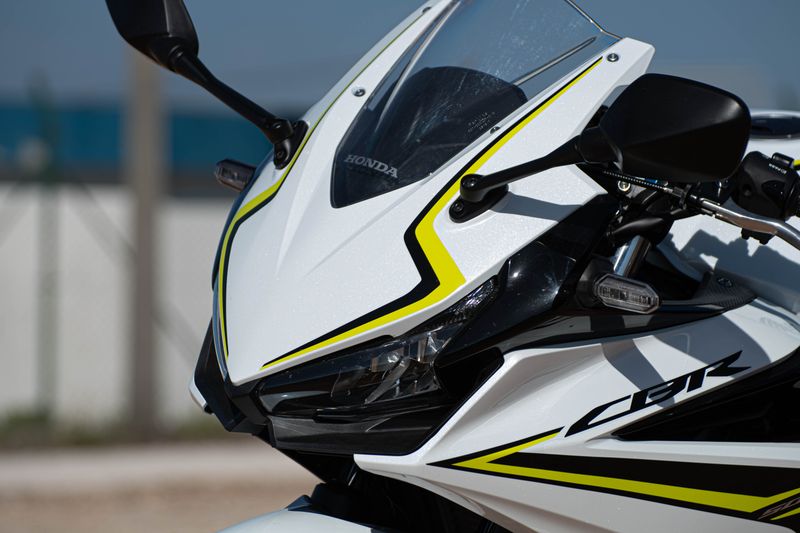 Vue rapprochée d'une moto Honda CBR blanche mettant en avant ses détails techniques