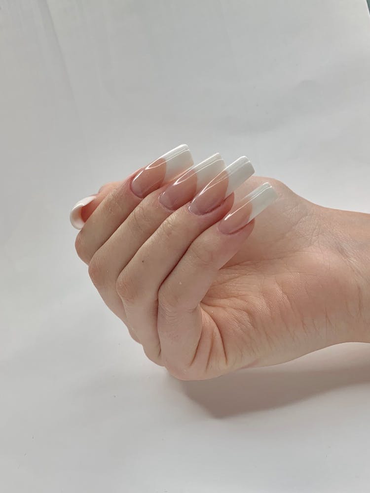 Persons Hand With White Nail Polish