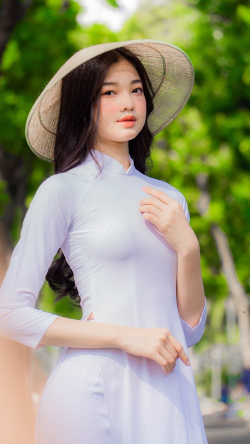 Beautiful Woman in White Long Sleeve Dress Wearing Her Conical Hat
