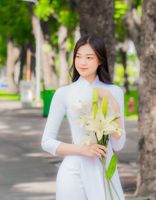 A Woman in an Ao Dai Holding Flowers