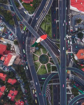 Aerial photograph of a busy Mexico City intersection featuring a prominent Mexican flag monument.