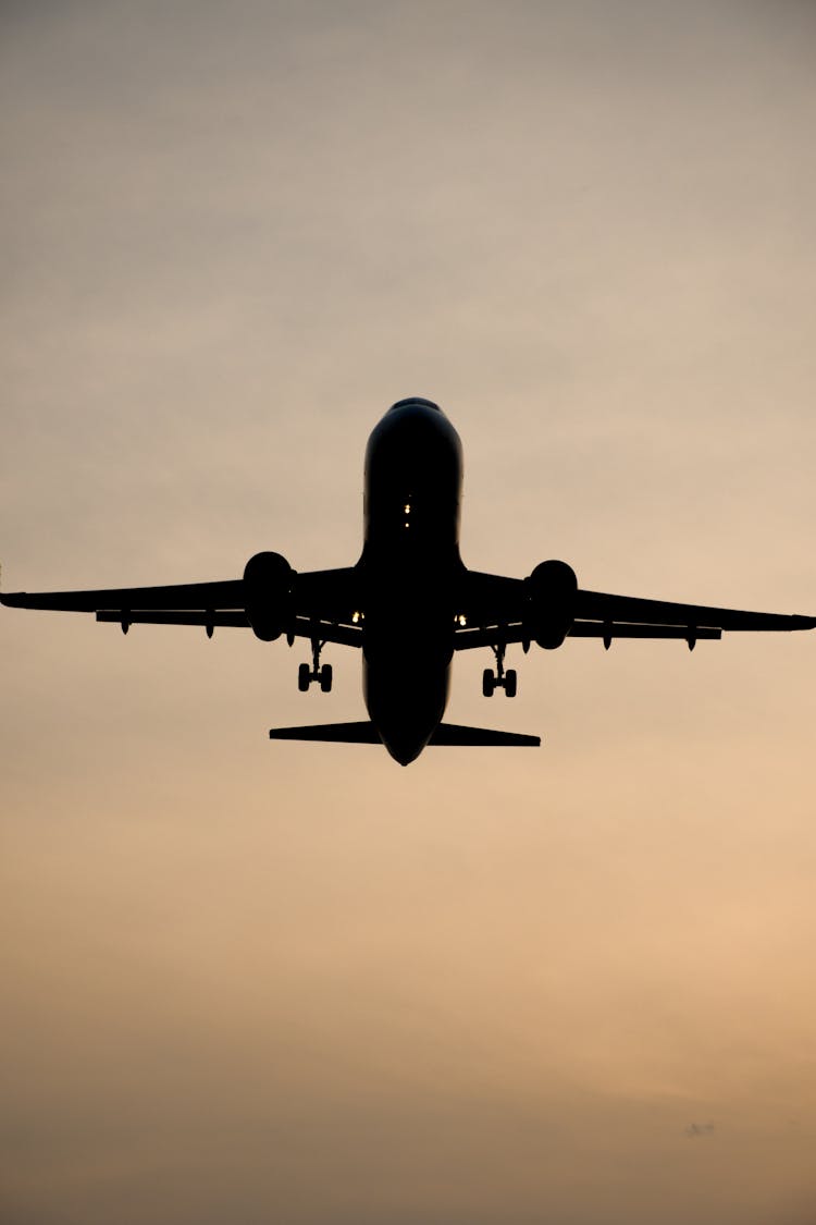 Silhouette Of A Flying Airplane In The Sky