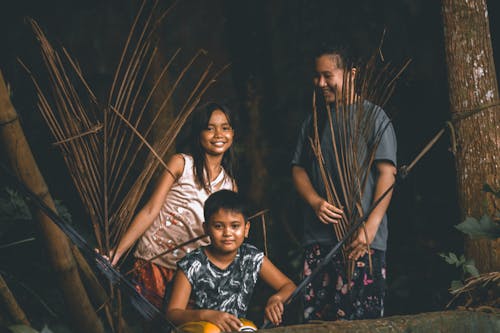 A Woman in Gray Shirt Standing Beside the Two Kids Near the Hammock