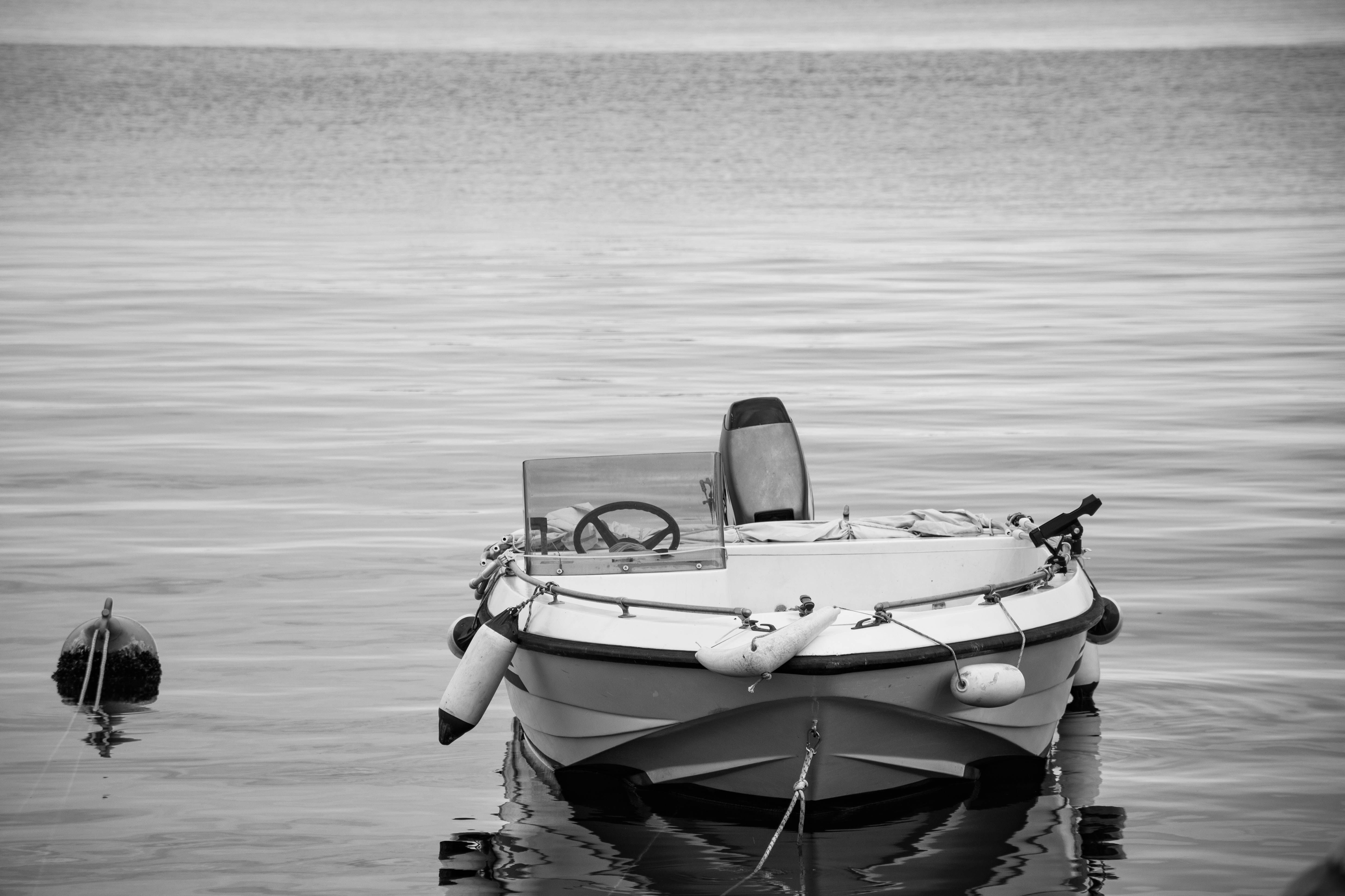 Grayscale Photo of a Boat on Body of Water · Free Stock Photo