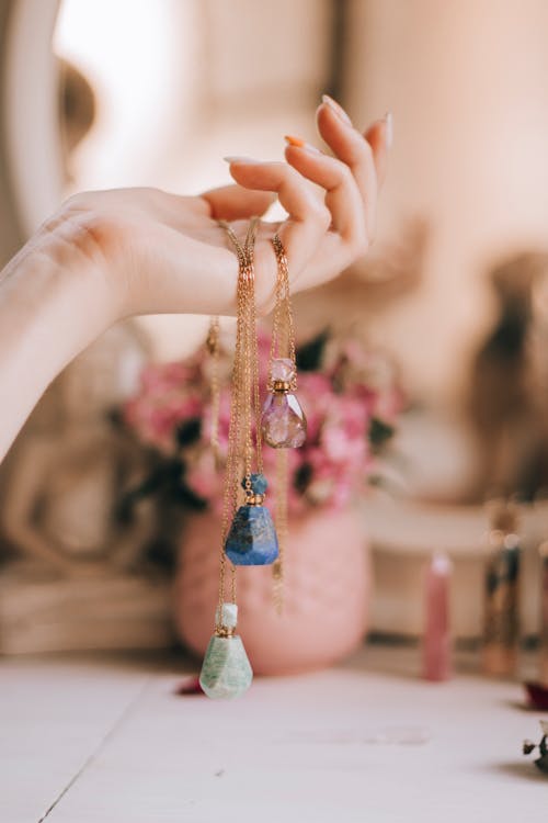 Woman Hand Holding Crystal Bottles Jewelry