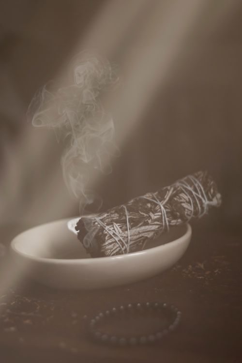 Free Sage bundle burning in a dish with swirling smoke, creating a calming atmosphere. Stock Photo