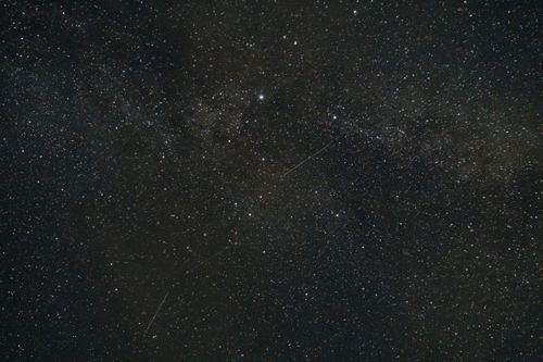Free Capture of the Milky Way with stars and shooting stars illuminating the night sky. Stock Photo