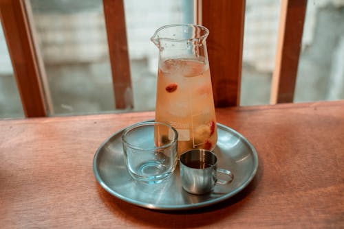 목조 테이블, 술을 마시다, 스테인리스 컵의 무료 스톡 사진