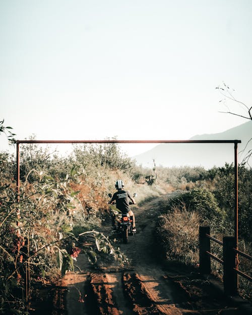 Person Riding a Motorcycle on Dirt Road