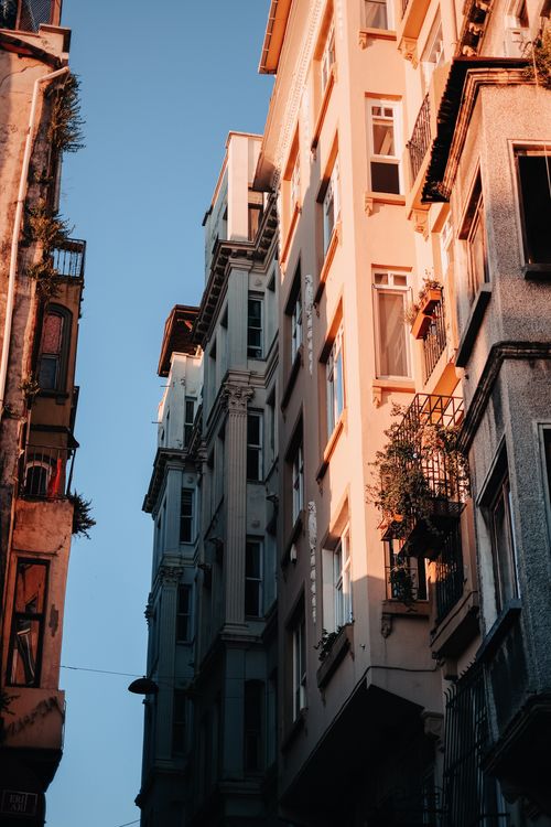 Free Low-angle view of sunlit buildings creating a warm urban atmosphere. Stock Photo